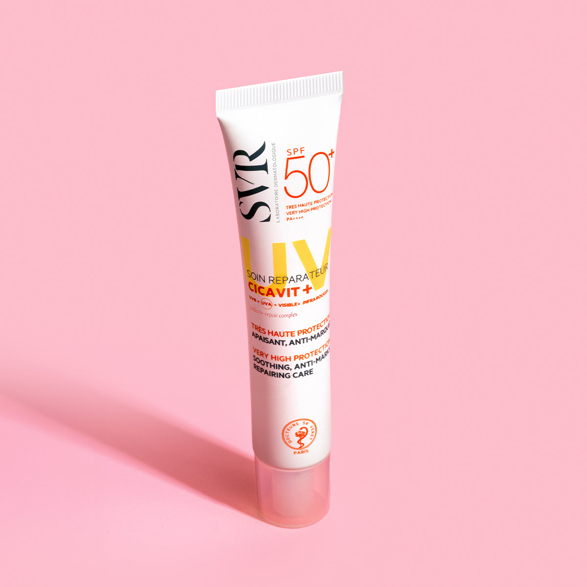 Tubo de creme SVR Cicavit+ SPF50+ branco com tampa transparente sobre fundo rosa pastel.