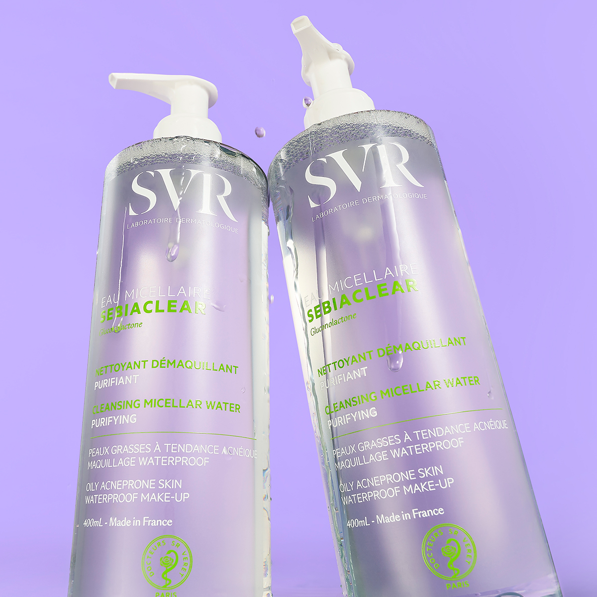 Dois frascos de 400ml de SVR Sebiaclear Eau Micellaire com doseador branco contra um fundo roxo suave.