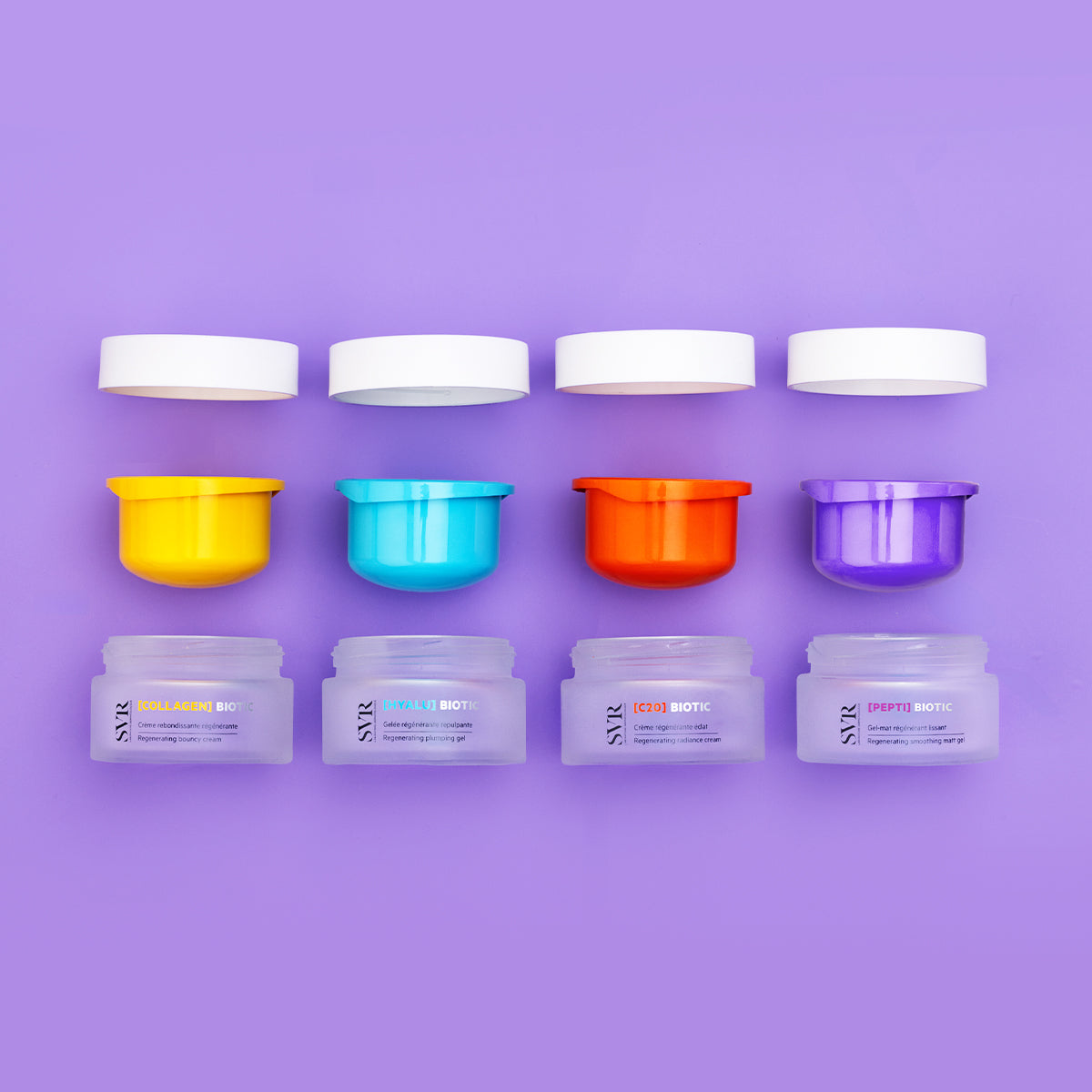Quatro boiões de creme SVR Biotic com tampas brancas e interiores coloridos sobre fundo roxo.