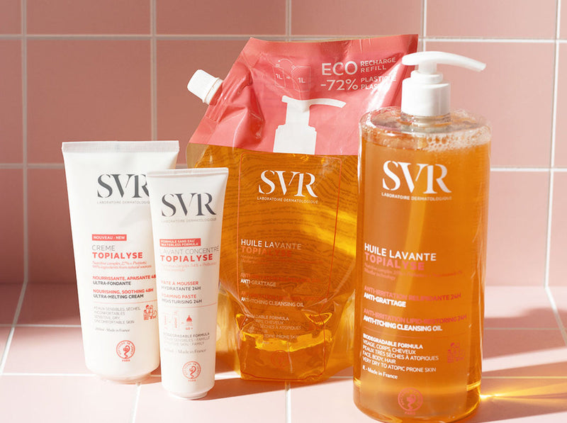 Produtos de cuidados corporais SVR, incluindo cremes e óleos de limpeza, sobre azulejos cor-de-rosa.