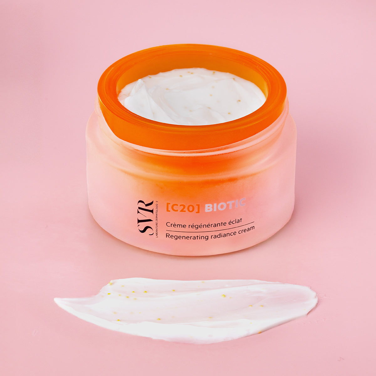 SVR [C20] Biotic regenerating radiance cream in an orange frosted glass jar with a white textured cream swatch.
