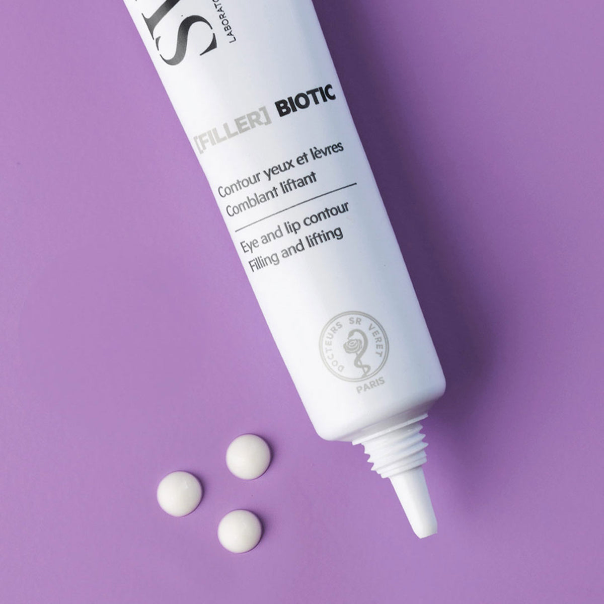 Tubo branco de creme [FILLER] BIOTIC para olhos e lábios sobre fundo roxo, com três pequenas gotas de produto ao lado.