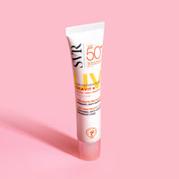 Tubo de creme SVR Cicavit+ SPF50+ branco com tampa transparente sobre fundo rosa pastel.
