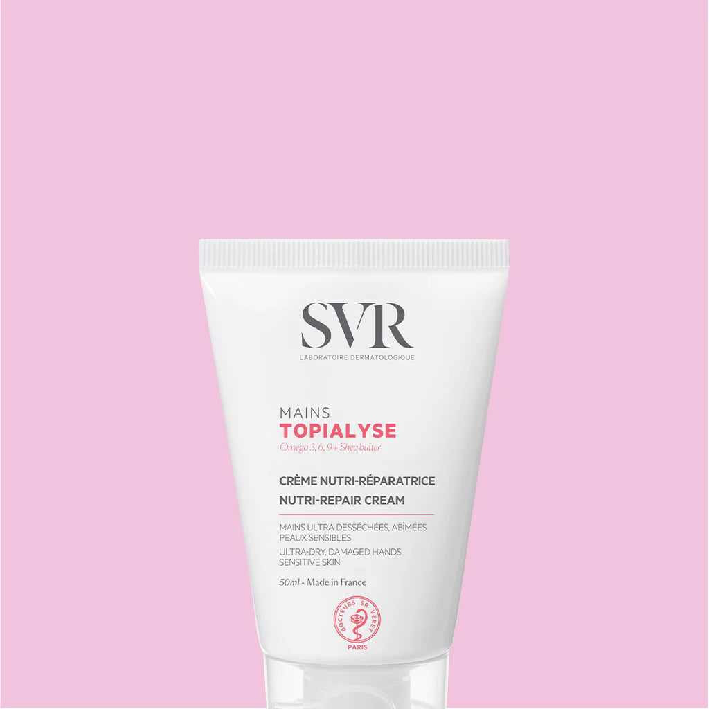 Bisnaga branca de 50ml do creme reparador SVR Topialyse Mains para mãos secas, sobre fundo rosa claro.