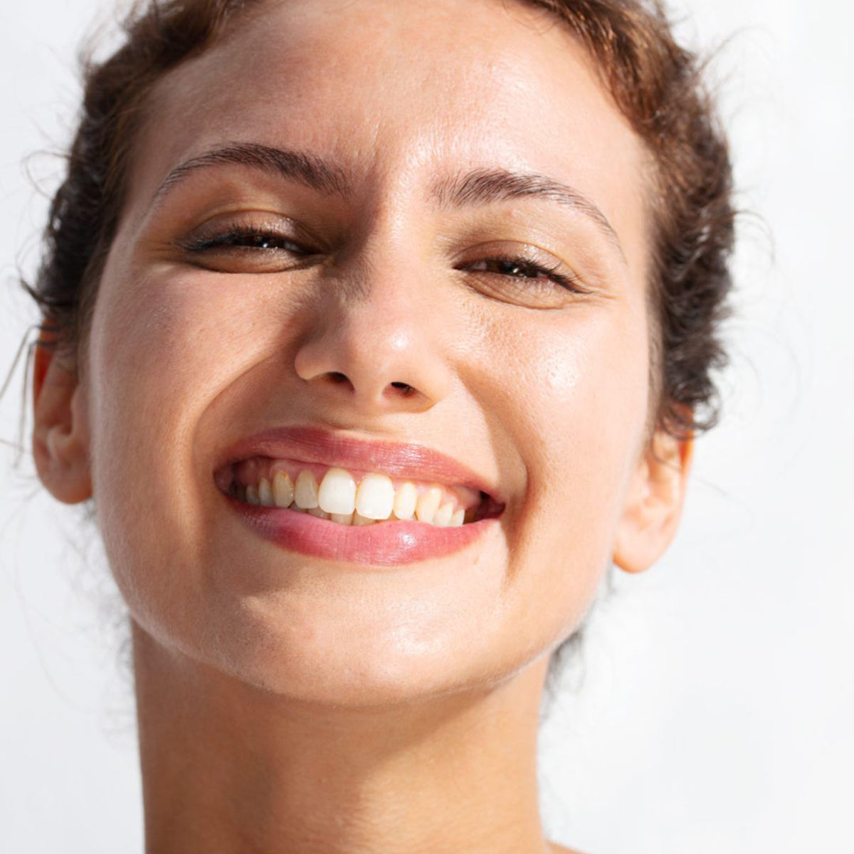 Mulher sorridente com pele saudável e luminosa, ideal para demonstrar a proteção solar SVR AK SECURE DM Protect.